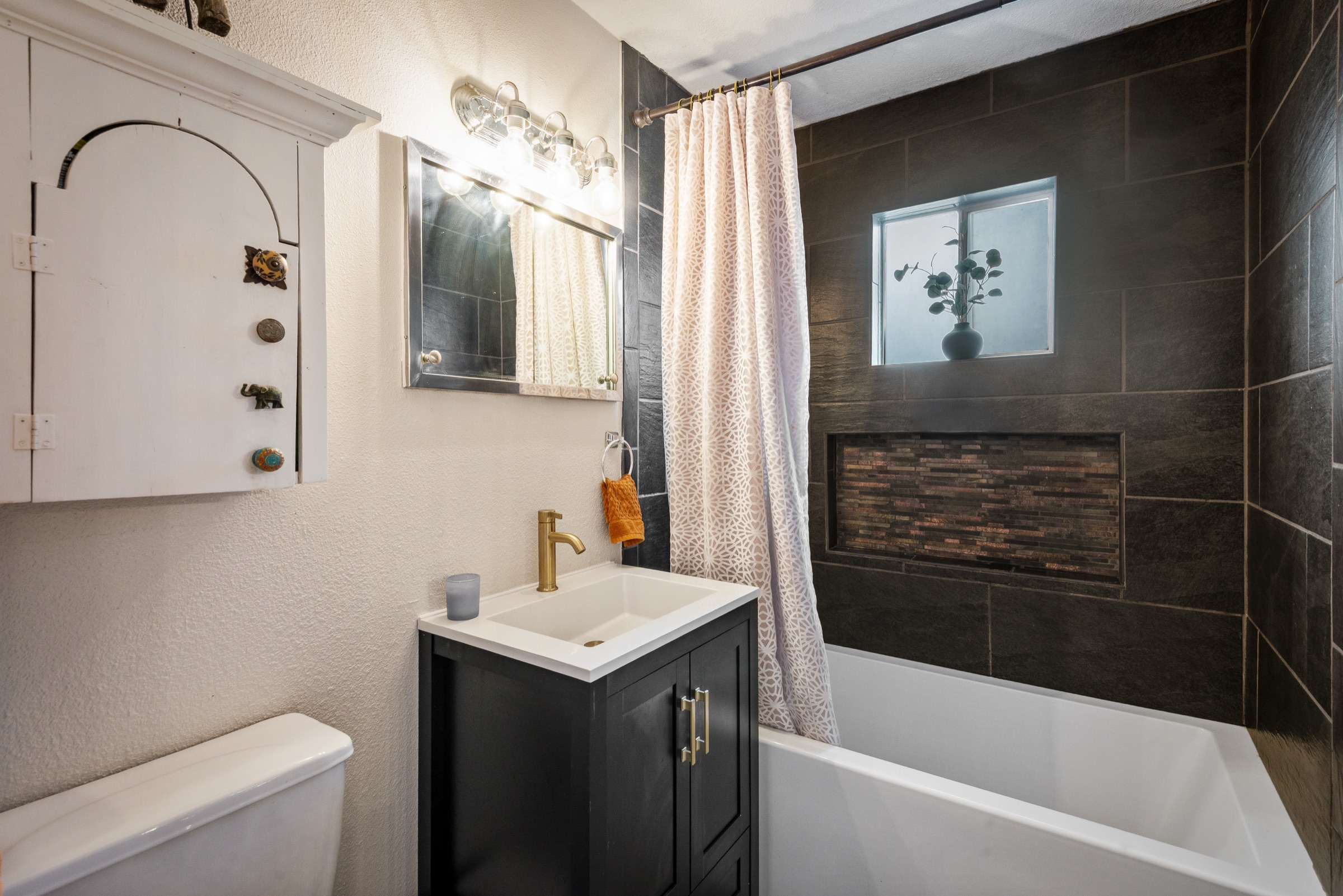 Primary bathroom: remodeled bath, vanity, and tile